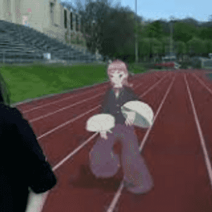 a girl walking on a football stadium with a virtual character behind her